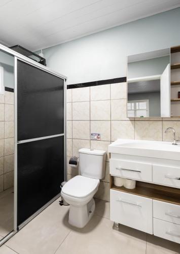 a bathroom with a toilet and a sink at Edícula Cambará in Cambará