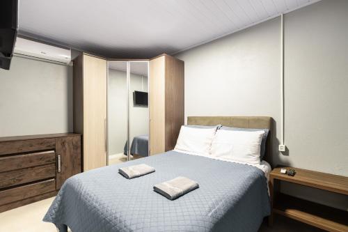 a bedroom with a bed with two towels on it at Edícula Cambará in Cambará