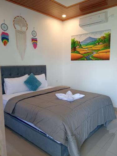 a bedroom with a bed with a painting on the wall at Compass Homestay in Huu