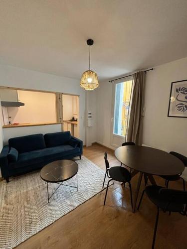 un salon avec un canapé bleu et une table dans l'établissement Centre histoire AAA, à Béziers