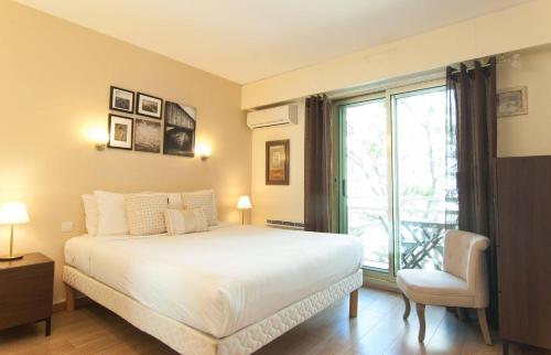 une chambre avec un lit, une fenêtre et une chaise dans l'établissement Elegant Apt w/2 Terraces/Mins to Beach & Shops, à Antibes