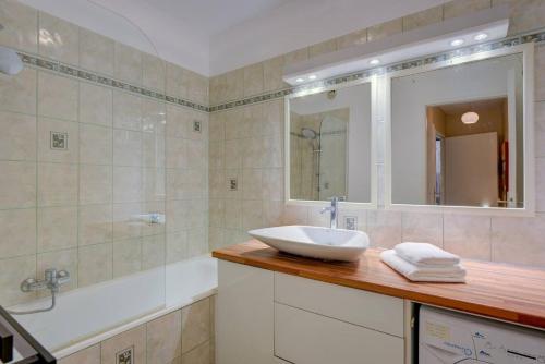 une salle de bain avec un lavabo, une baignoire et un miroir dans l'établissement Elegant Apt w/2 Terraces/Mins to Beach & Shops, à Antibes