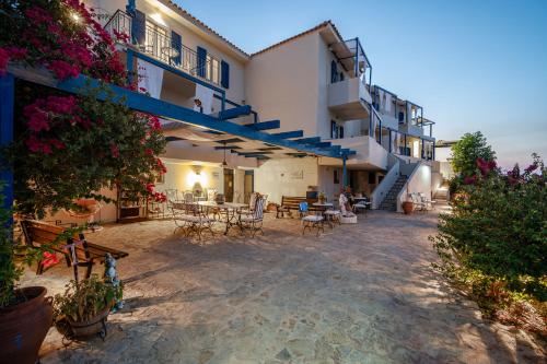 an outdoor patio of a building with tables and chairs at Agnadi Blue Apartments in Dhiakofti