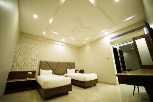 a bedroom with a bed and a desk and a piano at Sun Shine Hotel in Bengaluru
