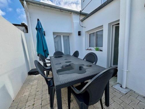 un patio avec une table, des chaises et un parasol dans l'établissement Maison cœur Quiberon, 5 pièces, 110m², 8 pers., WIFI, proche plage et commodités - FR-1-478-301, à Quiberon