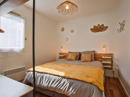 une chambre avec un lit et un lustre dans l'établissement Joli 2P avec jardin privé à Merville-Franceville, proche plage et commerces - FR-1-788-30, à Merville-Franceville-Plage