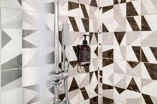 a shower in a bathroom with a black and white tiles at Penzion No 212 in Napajedla