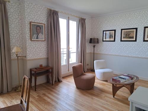 un salon avec une chaise et une table dans l'établissement Bright & elegant appartment with view over Invalides, near St Germain des Prés, à Paris