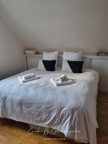 un lit blanc avec deux serviettes dessus dans l'établissement LA VILLA GOLF ET MER - 6 Pers LA FORET FOUESNANT, à La Forêt-Fouesnant