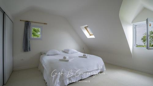 une chambre blanche avec un lit et une fenêtre dans l'établissement LA VILLA GOLF ET MER - 6 Pers LA FORET FOUESNANT, à La Forêt-Fouesnant