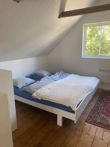 a bed sitting in a room with a window at Ferienwohnung auf dem Bauernhof in Mariannelund