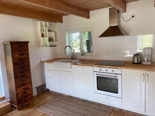 a kitchen with white cabinets and a sink at Ferienwohnung auf dem Bauernhof in Mariannelund