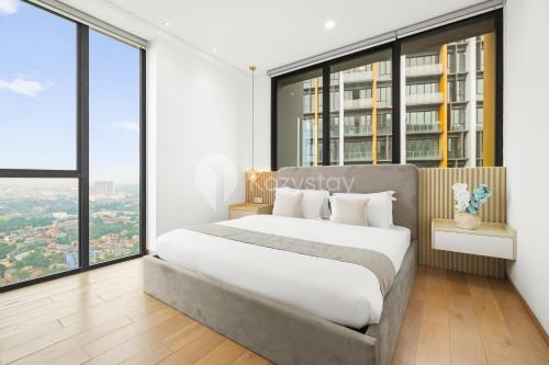 a bedroom with a large bed and large windows at Dorado by Kozystay - Cilandak in Jakarta