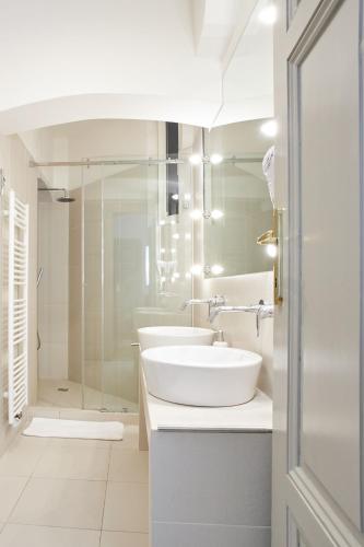a white bathroom with two sinks and a shower at Wenceslas Square Residence in Prague