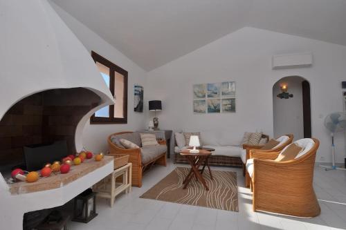 un salon avec une cheminée dans l'établissement Sea view villa - Cala Rossa private park, à Lecci