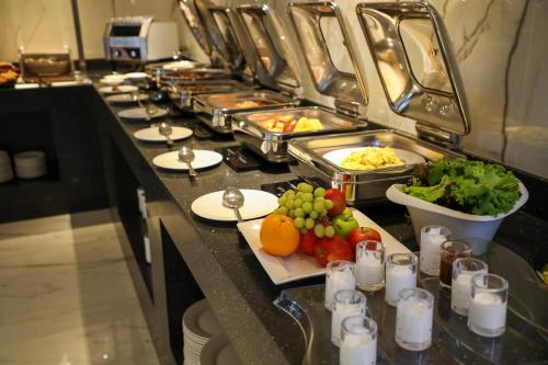 a buffet line with many dishes of food and vegetables at E Hotel in Al Madinah
