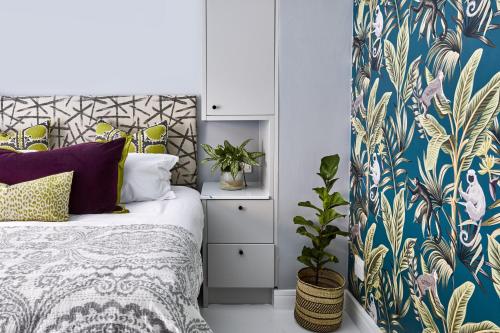a bedroom with a bed with a blue and gold wallpaper at Pineapple House Boutique Hotel in Cape Town