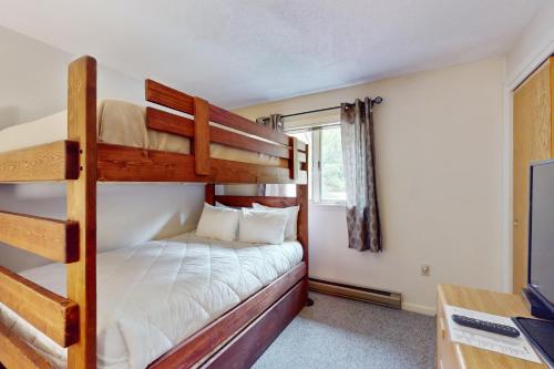 a bedroom with two bunk beds and a desk at Reindeer Crossing at Nordic Village in Bartlett