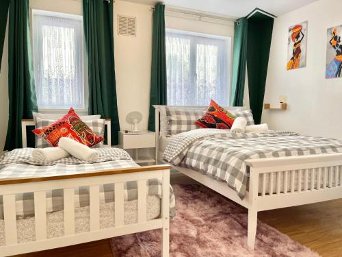 GoodmayesにあるThe Express Apartmentの緑のカーテンが備わるベッドルームのベッド2台