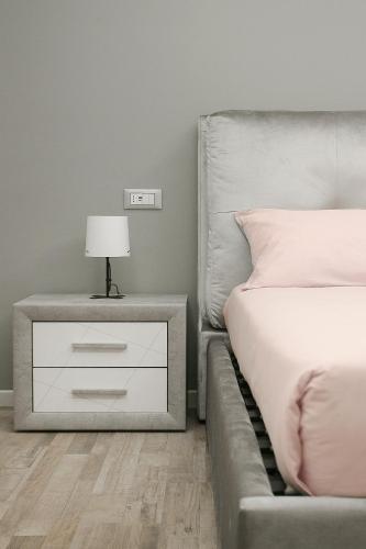 a bedroom with a bed and a nightstand with a lamp at Leyla's House in Gorle