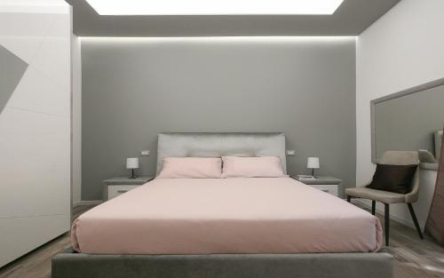 a white bedroom with a bed and a chair at Leyla's House in Gorle