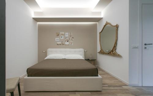 a white bedroom with a bed and a mirror at Leyla's House in Gorle