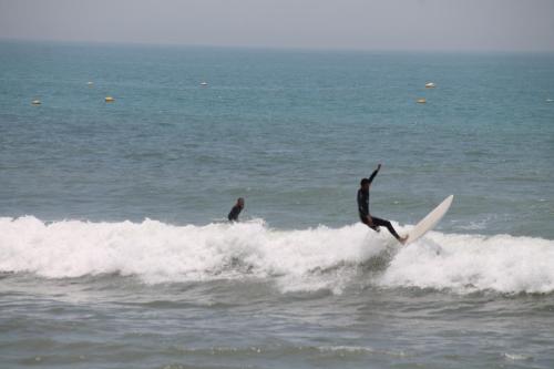 a man riding a wave on a surfboard in the ocean at aziz house of surfing in Tagant