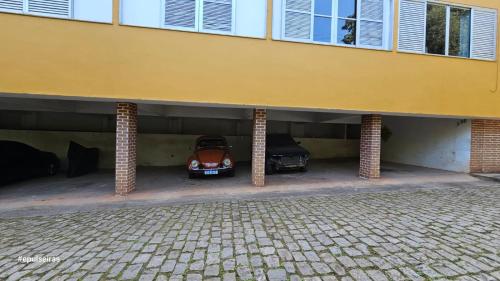 a garage with a car parked underneath a building at Apê210MiguelPereira in Miguel Pereira