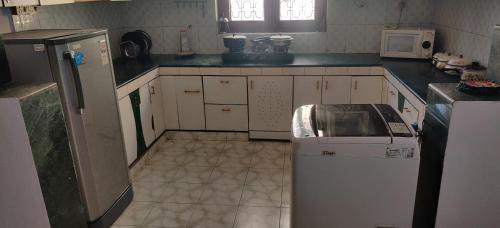a kitchen with a refrigerator and a tiled floor at Park View in Gomti Nagar