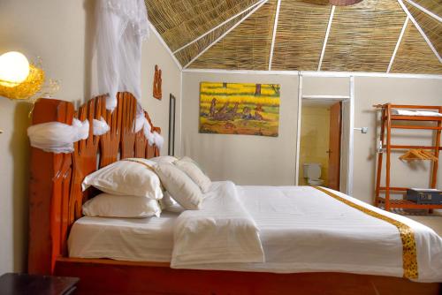 a bedroom with a large bed with a wooden headboard at Mara Chui Eco-Resort in Sekenani