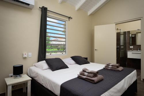 a bedroom with a large bed with towels on it at All Seasons Apartments in Kralendijk