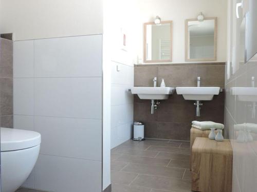 a bathroom with two sinks and a toilet at Penthaus an der Harle in Carolinensiel