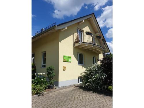 a building with a balcony on the side of it at Holiday apartment in the rose garden in Birach