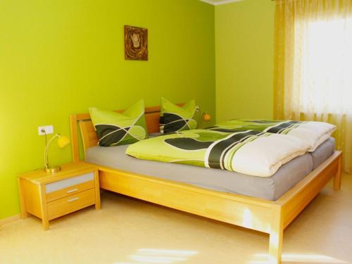a bedroom with a bed with green walls at Holiday apartment in the rose garden in Birach
