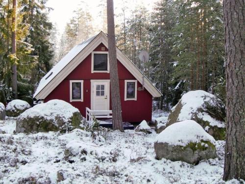 a small red cabin in the woods in the snow at Modern apartment in Vimmerby in Vimmerby