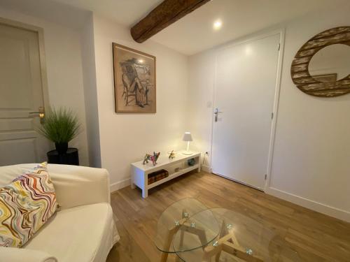 a living room with a couch and a glass table at La Papaline de Caroline in Saint-Saturnin-lès-Avignon