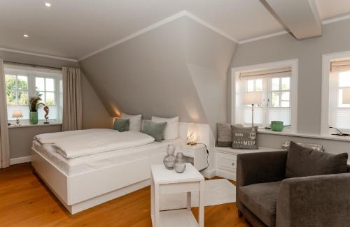 una camera da letto bianca con un letto e un divano di LITZKOW 16204 ad Archsum