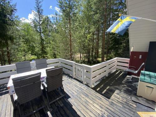 a deck with chairs and a table and a flag at Modern apartment in Vimmerby in Vimmerby