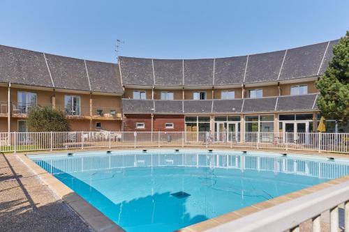 une grande piscine devant un immeuble dans l'établissement Studio Escapade Normande - Welkeys, à Équemauville