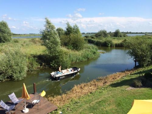 a man in a boat on a river at Beachvilla Grachtenblik in Makkum