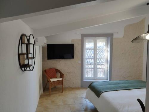 une chambre avec un lit et une télévision sur un mur dans l'établissement La Montée du Château, à Grignan