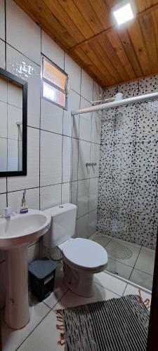 a bathroom with a toilet and a sink and a shower at Suites Casa da sua mãe in Visconde De Maua