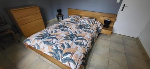 a bed in a bedroom with a bedspread on it at Maison de plein pied avec jardin privatif centre ville in Milly-la-Forêt
