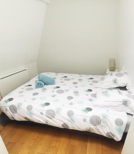 - une petite chambre avec un lit avec des points de polka dans l'établissement Les quais de Trouville, à Trouville-sur-Mer