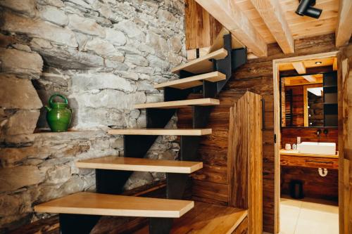 ein Raum mit Holzregalen und einer Steinwand in der Unterkunft Chalet des Amis by Lodji in Saint-Marcel