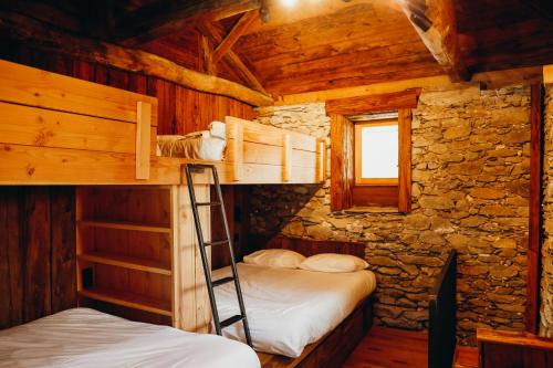 2 Etagenbetten in einem Blockhaus mit einem Fenster in der Unterkunft Chalet des Amis by Lodji in Saint-Marcel