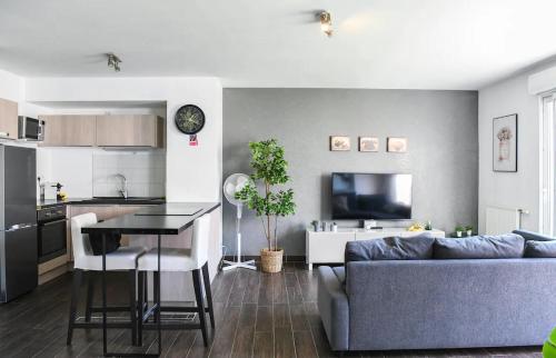un salon avec un canapé bleu et une cuisine dans l'établissement Superbe appartement avec Terrasse, piscine & Parking Privé à Marseille, à Marseille