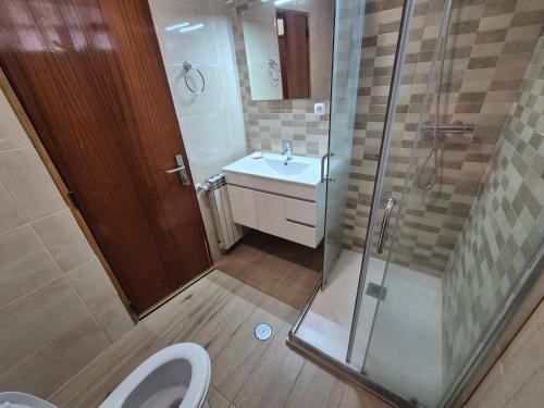 a bathroom with a shower and a toilet and a sink at Joe's House in Fátima