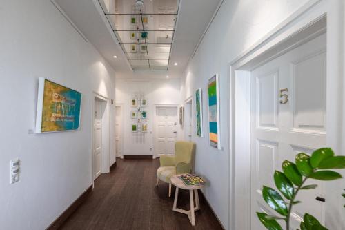 a hallway of an office with a chair and a table at Villa Benz Hotel garni in Schwetzingen