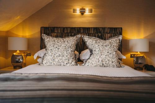 a bedroom with a bed with pillows and two lamps at Windermere Hillthwaite Hotel in Windermere